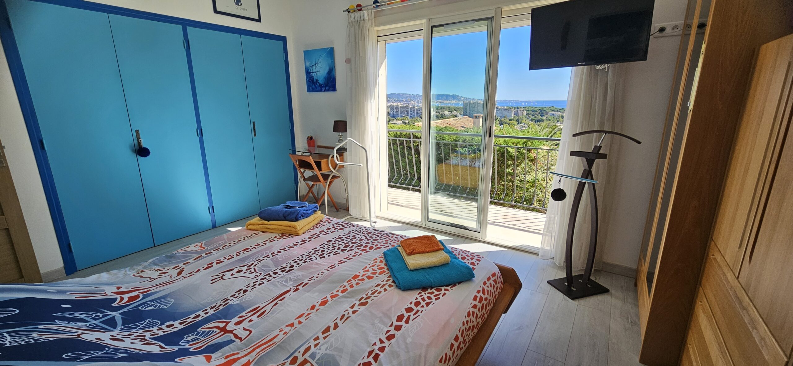 Photo de la chambre numéro 1 du rez-de-chaussée, vue du côté droit avec baie vitrée donnant sur le balcon et vue sur la mer.