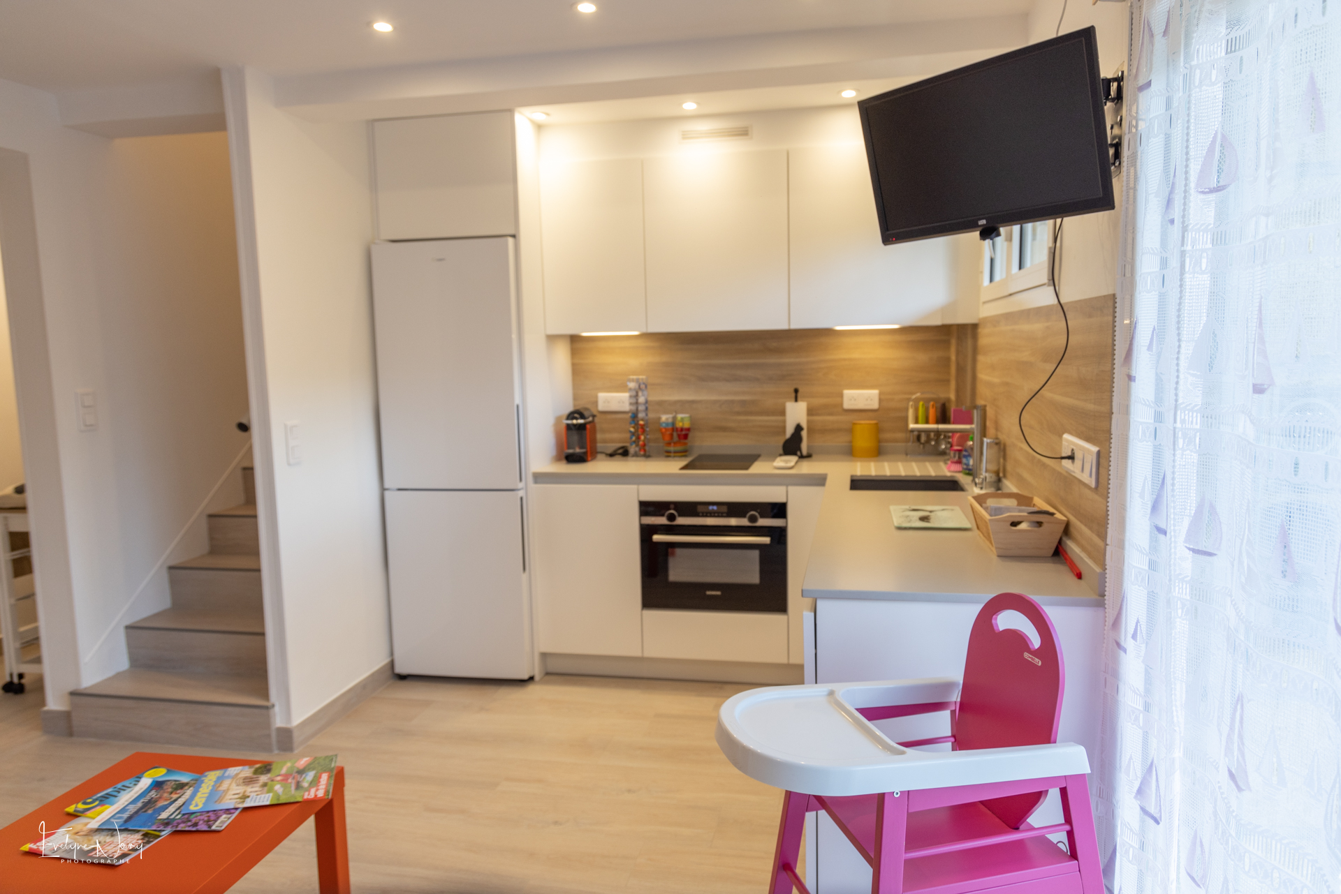 Cuisine ouverte de l'appartement en rez-de-jardin. Avec chaise bébé et tous les équipements nécessaires. Cuisine neuve.