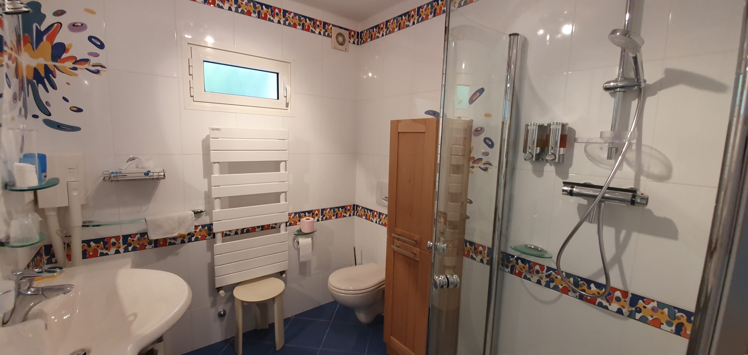 Photo de la salle d'eau de l'appartement en rez-de-jardin ; 1 vasque, 1 radiateur mural, 1 seche-cheveux mural, 1 wc, 1 douche d'angle.
